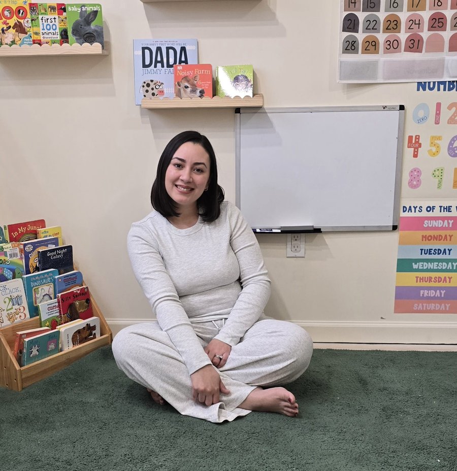 AMISA's lead teacher sitting in the reading corner of the daycare